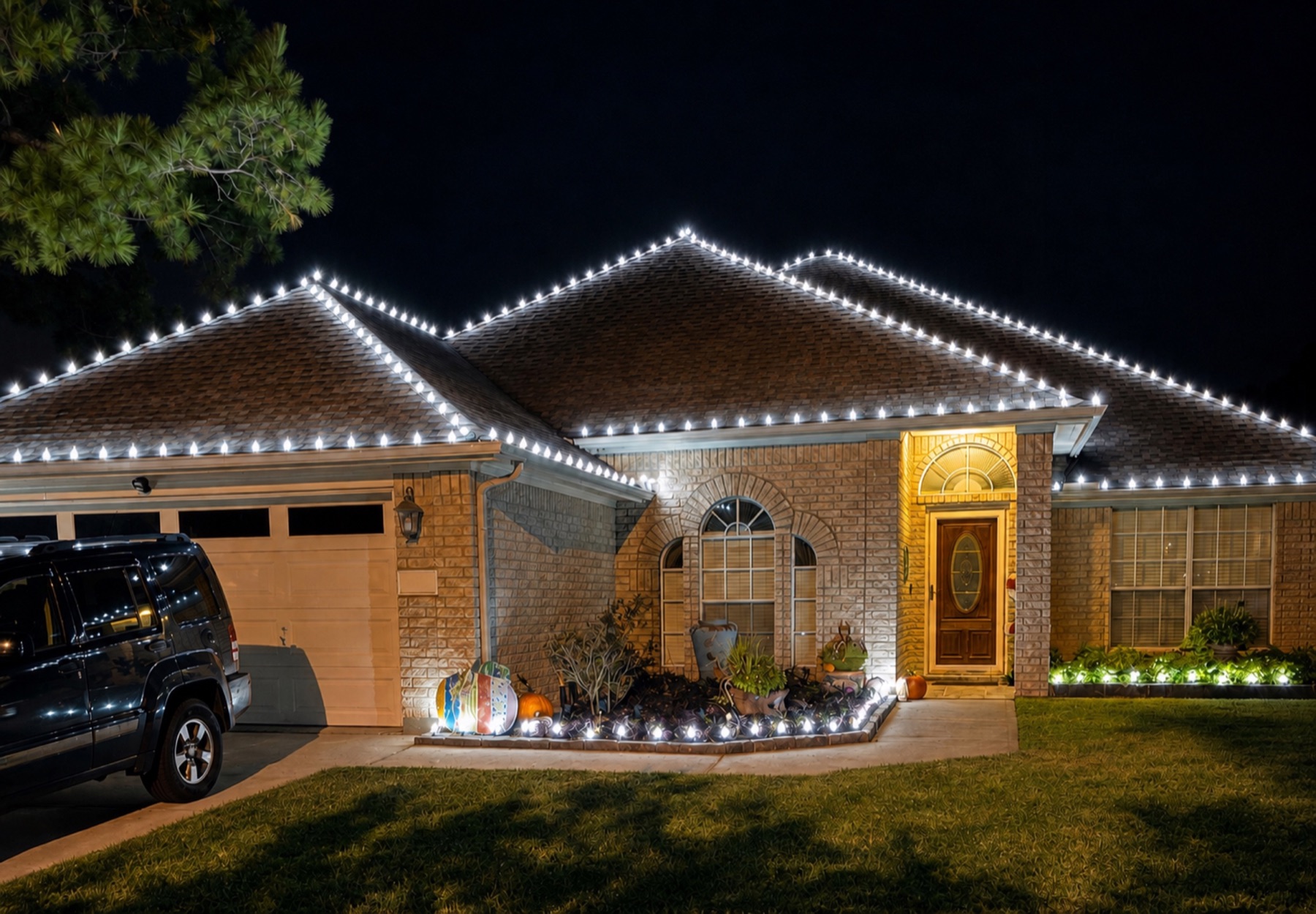 Single-story brick home with bright cool-white lights precisely outlining the roof and front garden.